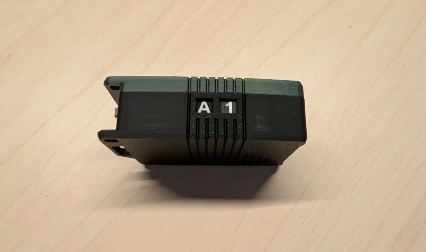 Side of the Atlavox M1 showing the A1 dice identifier between the green top and black bottom