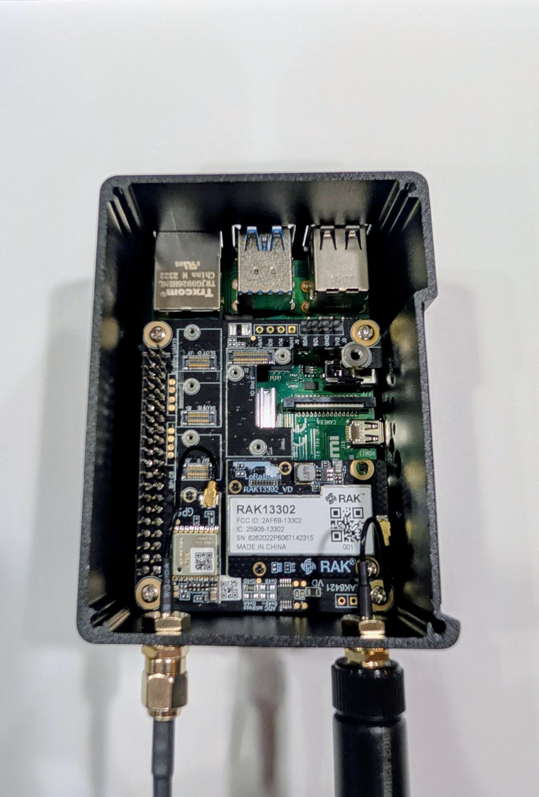 Lid removed from the WisMesh Station HP showing the RAK6421 HAT, the RAK13302 LoRa module, the GNSS module, and the Raspberry Pi 4 underneath